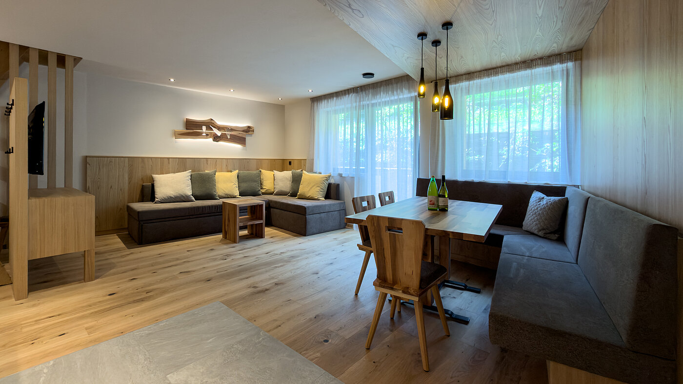 roßzügiger Wohnbereich im Bio-Wein-Apartment Südtirol Wohnbereich, Ferienwohnung, Bio-Weingut Santer, Südtirol, Mühlbach, Essecke, Sofa, Holzinterieur, Pustertal, Unterkunft