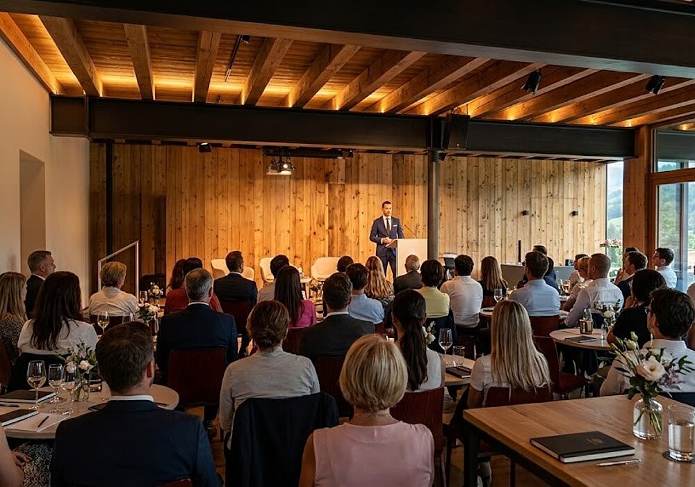 Seminarraum & Tagungen in Südtirol | Weingut Santer Blick von hinten auf das sitzende Publikum bei einem Vortrag oder Seminar in einer modernen Eventlocation mit warmer Holzoptik