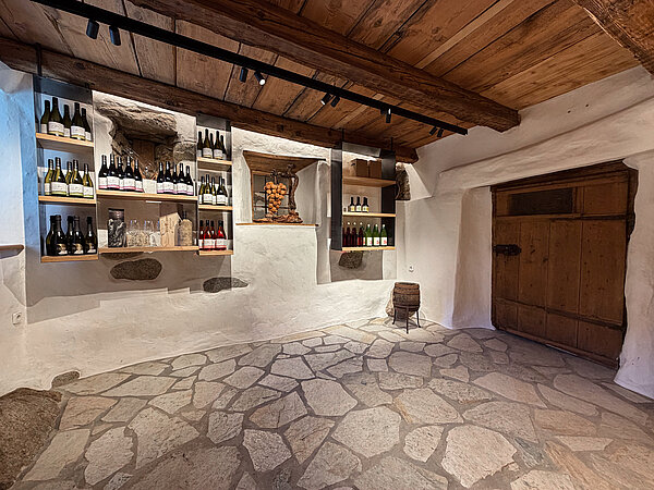  Historischer Hofladen mit Steinboden, Holzdecke und Weinregalen voller Bio-Weine im Weingut Santer in Mühlbach.