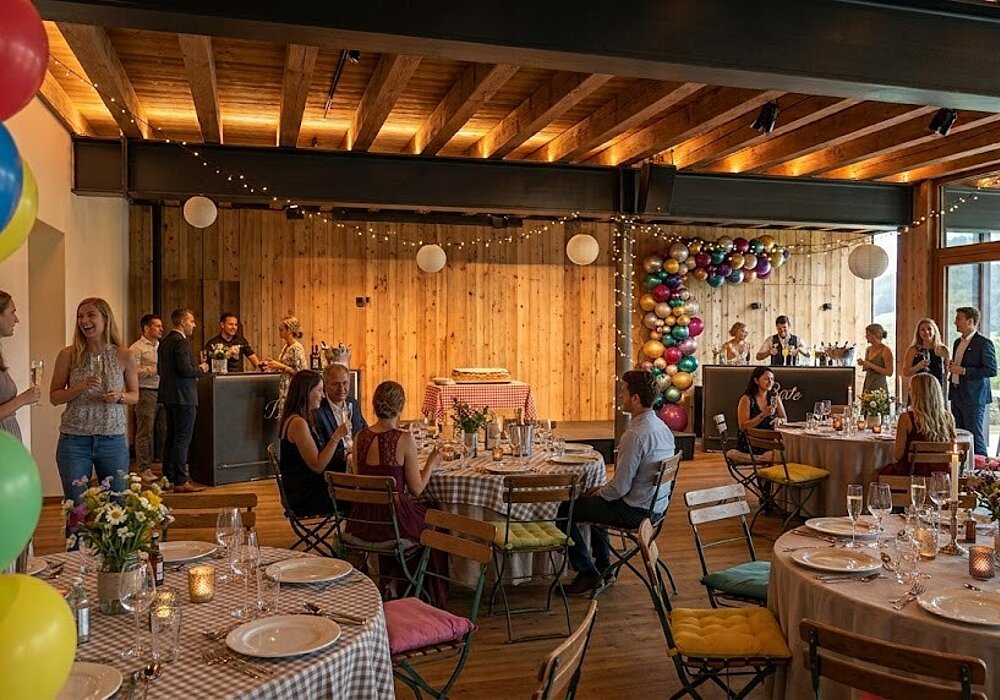 Private Feiern & Feste in Südtirol | Weingut Santer Festlich dekorierter Innenraum einer modernen Eventlocation mit Holzwänden, Luftballons, Lichterketten und Gästen an gedeckten Tischen bei einer Feier.